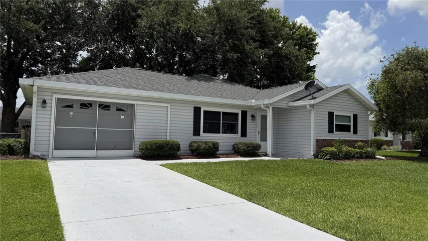 Front exterior with driveway, garage, and landscaped yard