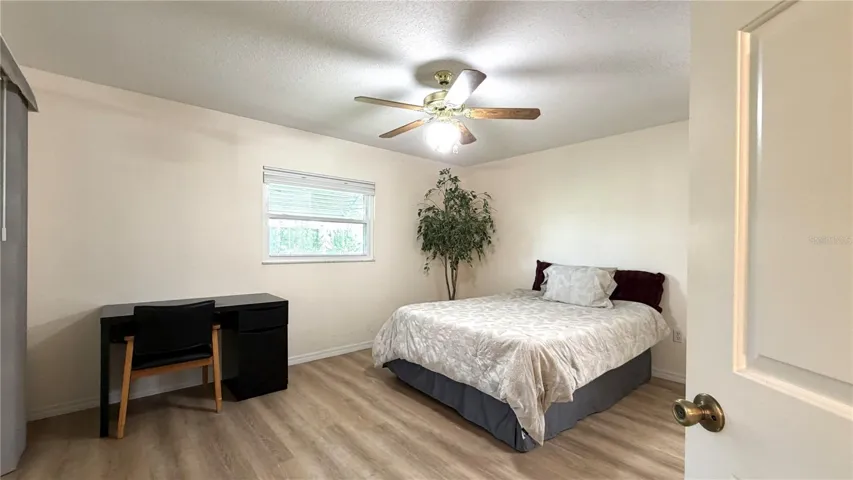 Primary bedroom with luxury vinyl flooring and ceiling fan