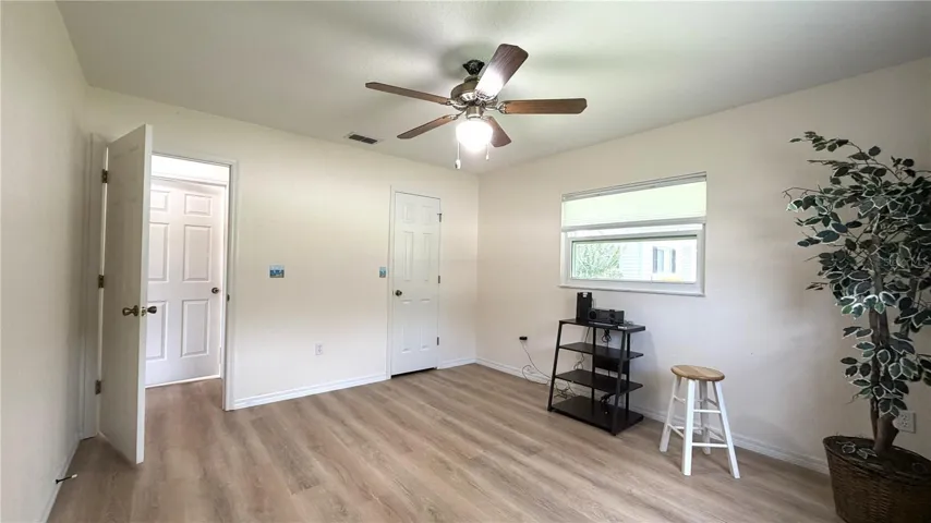 Bedroom 2 alternate view with closet, window, and luxury vinyl flooring