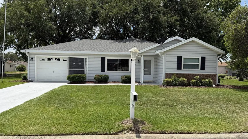 Front exterior with mature landscaping and extended one-car garage