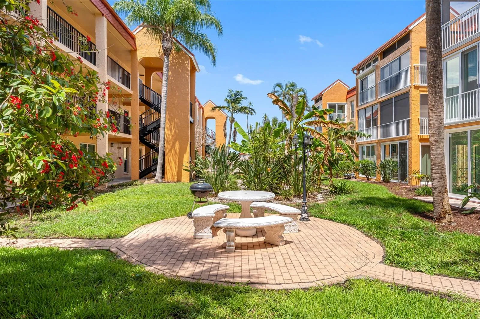 Courtyard of the condo 141. Picnic table and grill for outside cooking.  Each of the 4 courtyards has a picnic table and grills. The area outside the pool also has a picnic table and grill.