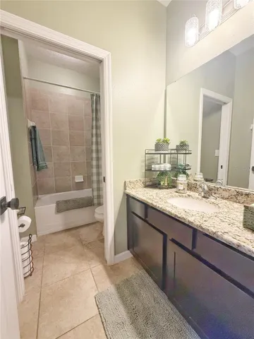 Additional view of bathroom two with pocket door leading into the water, closet and tub/shower area, granite countertops, ceramic tile, Tile Flooring
