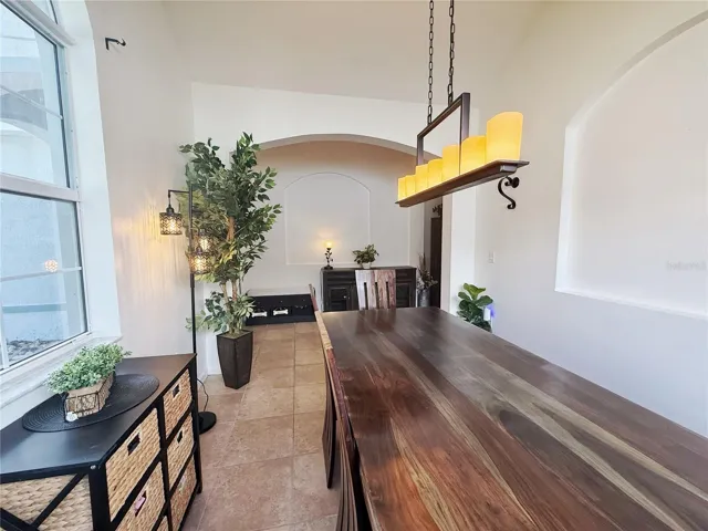 Dining room with ceramic tile flooring, view of Entry, decorative niche, vaulted ceiling