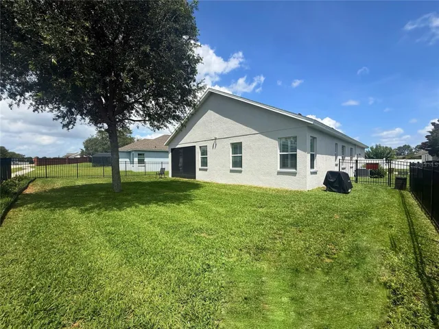 View of the fenced in backyard and screened in back porch