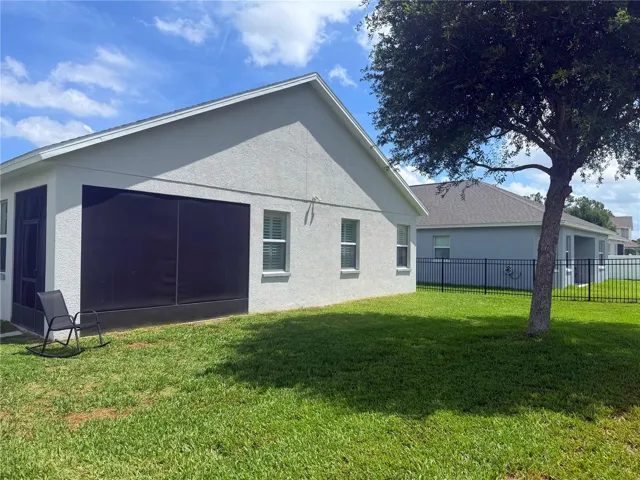 Additional view of the backyard and screened in covered back porch