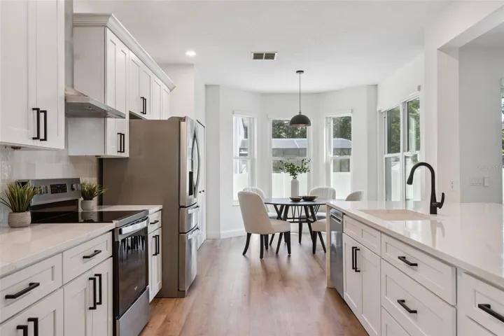 Sleek modern kitchen featuring stainless steel appliances, quartz countertops, shaker-style cabinetry, and abundant storage. The open layout offers both functionality and contemporary appeal.