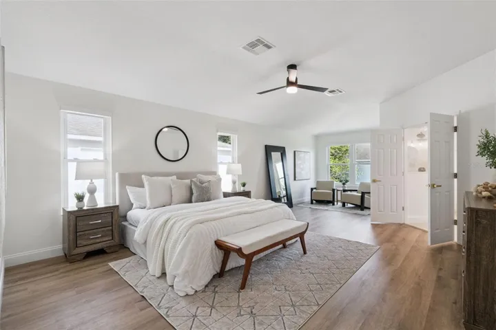 Oversized primary suite featuring generous natural light, wood-look flooring, and ample room for a private sitting area. A peaceful retreat with a bright and airy feel.