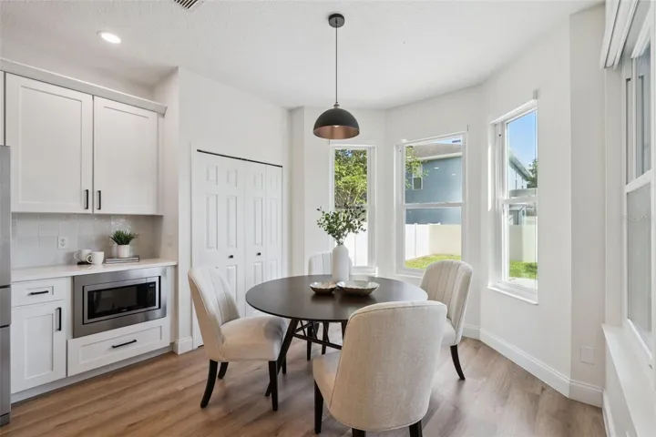 Cozy breakfast nook surrounded by large windows, offering a bright and cheerful space for casual dining or morning coffee.