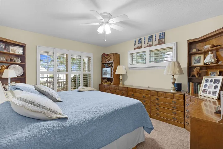 PRIMARY BEDROOM WITH PLANTATION SHUTTERS, CARPET, WALK IN CLOSET