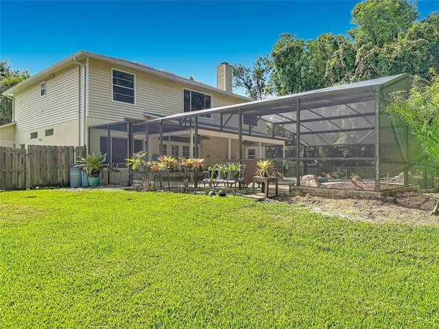Rear elevation showcasing the expansive screened pool enclosure and outdoor entertaining space