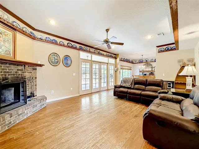 Expansive family room featuring a wood-burning fireplace and pool views