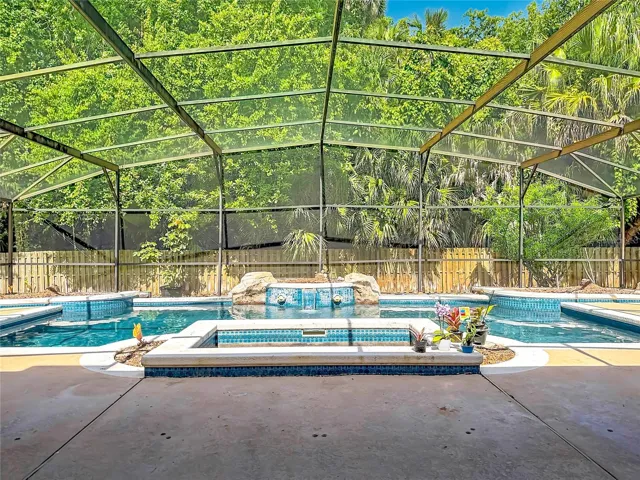 Large screen-enclosed pool and spa with waterfall feature and exceptional privacy