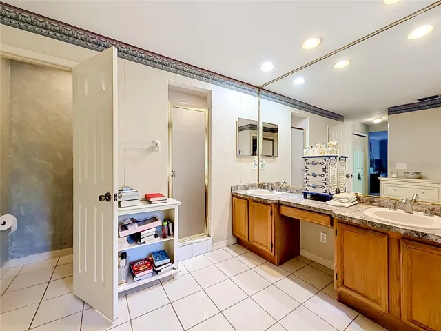 Spacious primary bathroom with dual vanities, walk-in shower, and garden tub