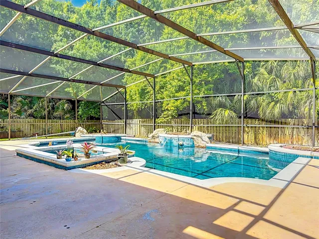 Spacious pool deck surrounded by mature landscaping and a private conservation backdrop