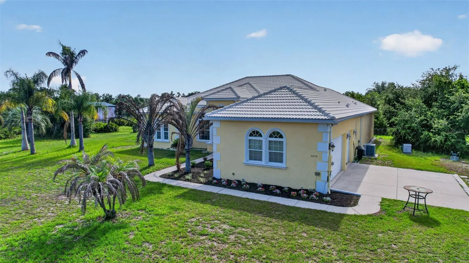 Set back from the road and framed by mature palms and a private pond, the residence enjoys both privacy and picturesque surroundings
