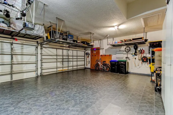 Garage is outfitted with 5 large overhead storage racks that all convey with the house
