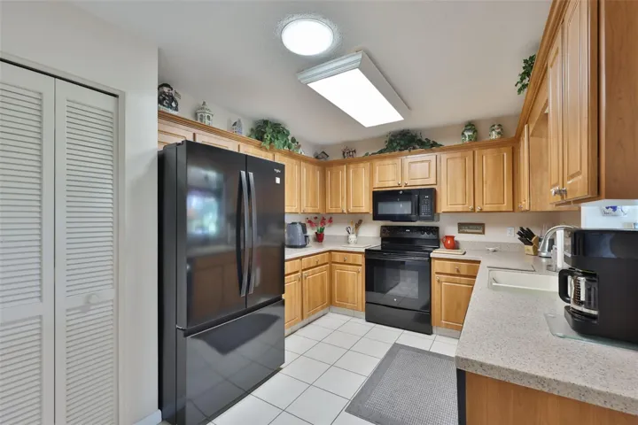 Kitchen, Wood Cabinets, Corian Countertop, Pantry, &amp; Solar Tube