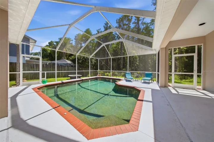 Beautiful salt water pool with a brown pebble tech.