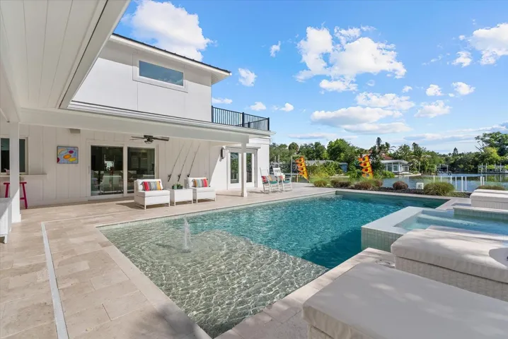 Large heated saltwater pool with sun shelf, fountain and spa using Pentair smart technology.