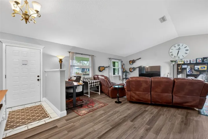 Living Room with wood look tile and vaulted ceilings.