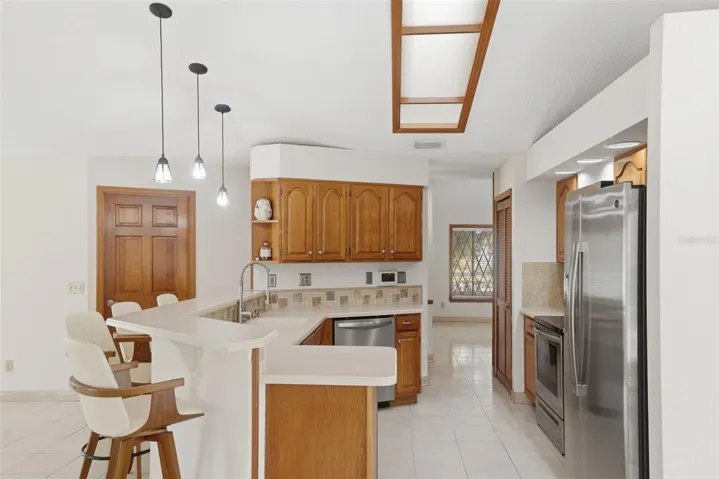 Well-appointed kitchen overlooking den features stainless steel appliances and Corian countertops
