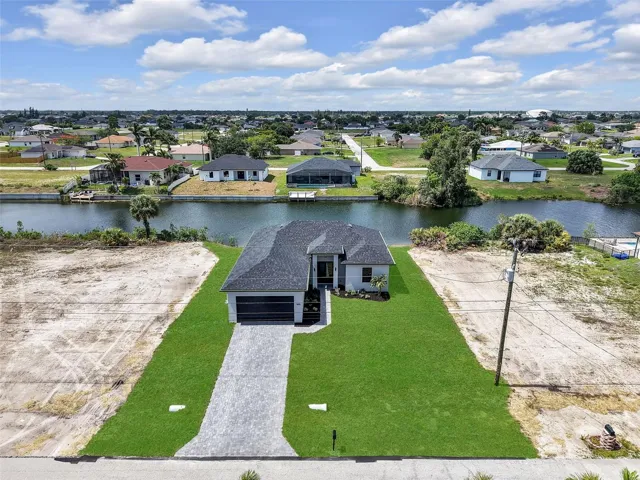 Contemporary single-story residence featuring a dark shingle roof, a paver driveway, and a two-car garage
