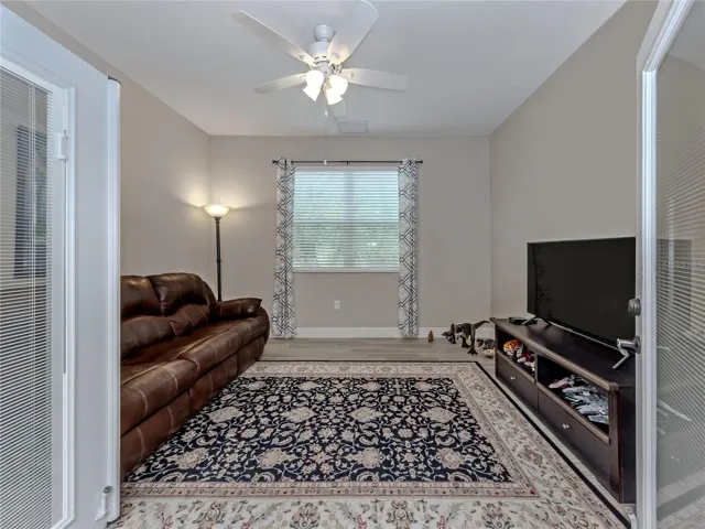 The large den features double glass doors and is located in the heart of the home