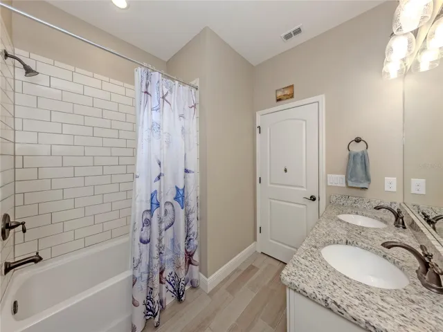 This second full bath with dual sinks, solid wood soft close cabinetry with updated tiled shower is so spacious and near the additional bedrooms!