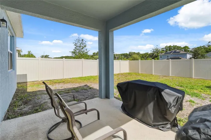 Relax and unwind on the back porch overlooking the spacious backyard at the end of a long day.