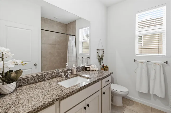 Charming second bathroom with tasteful design details and upgraded countertop finishes