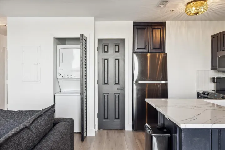 View of kitchen and closet with stack washer/dryer unit