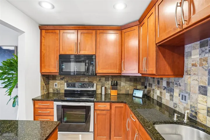The beautiful Kitchen is sure to impress with its abundance of cabinetry, GRANITE COUNTERTOPS, stainless steel appliances, CHIC TILE BACKSPLASH, and center island that adds both functionality and style.