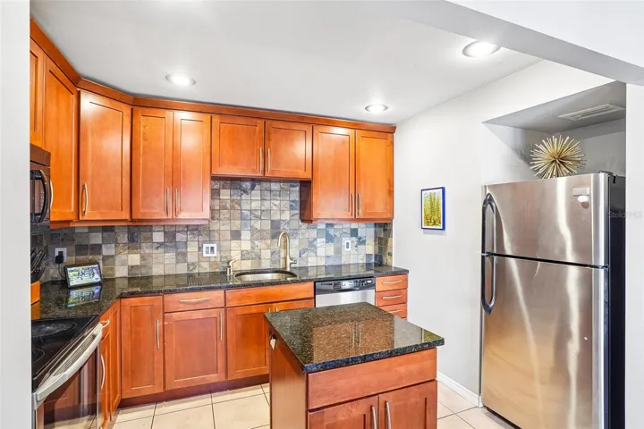 The beautiful Kitchen is sure to impress with its abundance of cabinetry, GRANITE COUNTERTOPS, stainless steel appliances, CHIC TILE BACKSPLASH, and center island that adds both functionality and style.