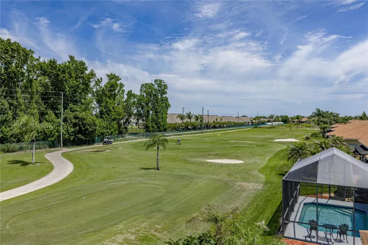 View from back of the house with golf cart path across the fairway