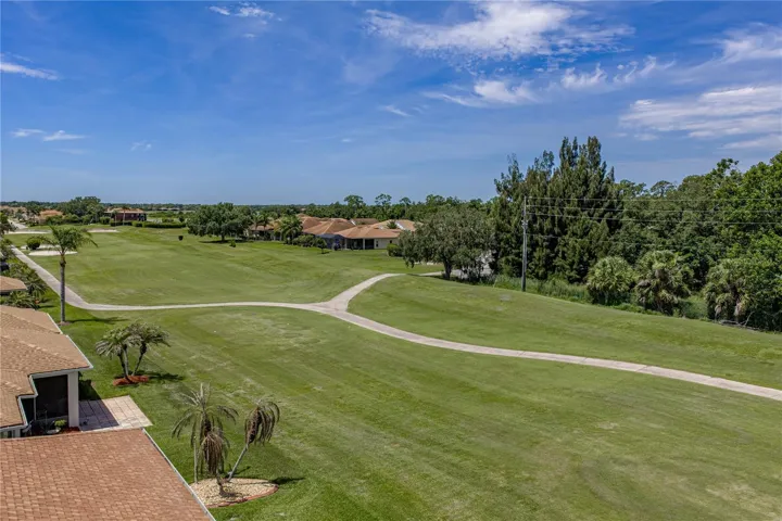 View from back of the house with golf cart path across the fairway