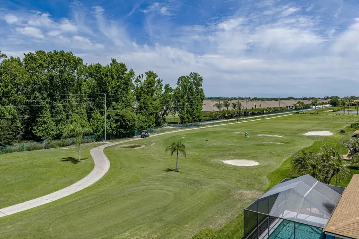 View from back of the house with golf cart path across the fairway