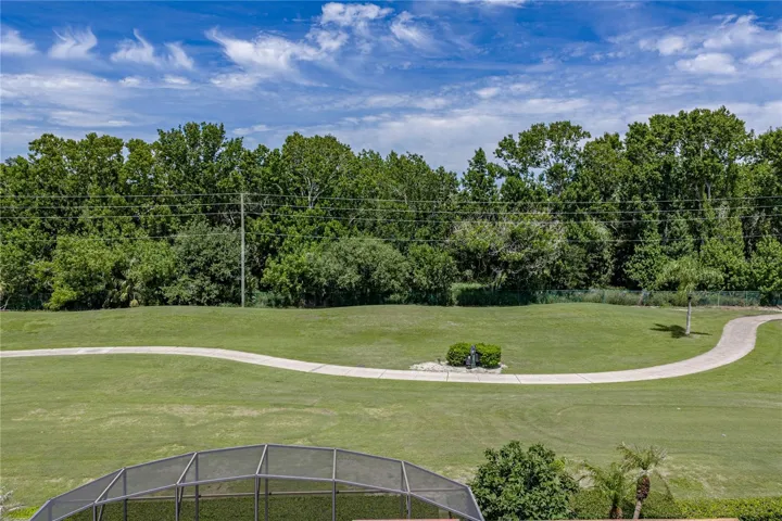 View from back of the house with golf cart path across the fairway