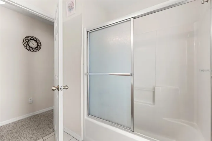 Bathroom featuring a glass enclosed tub shower combo