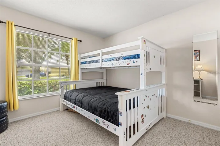 Secondary bedroom with bunk beds and cheerful window treatments
