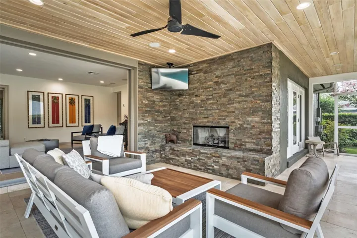 Lanai with floor to ceiling stone accent wall and gas fireplace