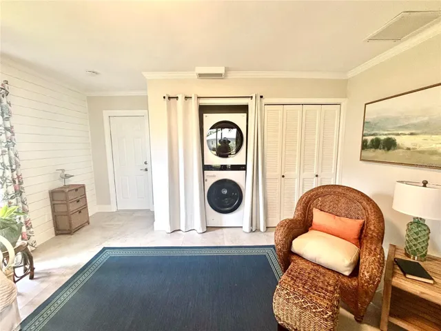 . This clever flex space also neatly houses a modern stackable washer and dryer hidden behind elegant privacy curtains.