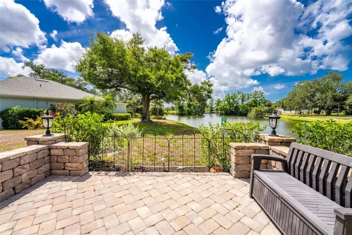 Relax on the beautiful brick paver patio complete with custom stone retaining walls, overlooking a tranquil water view and mature trees.