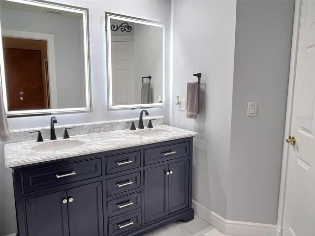 This is the bathroom that has direct entry from Bedroom 2.  It has been fully remodeled.  It has marble floors and counter top, plus lighted and heated mirrors to remove the fog after a steamy shower.