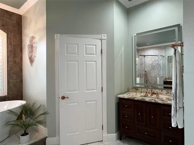Fully remodeled primary bathroom highlights copper finishes and it is a designers dream.  Two separate vanities with stone counter tops.