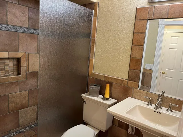 This bathroom is shared by Bedroom 4 and 5.  It has a full shower with a glass enclosure.
