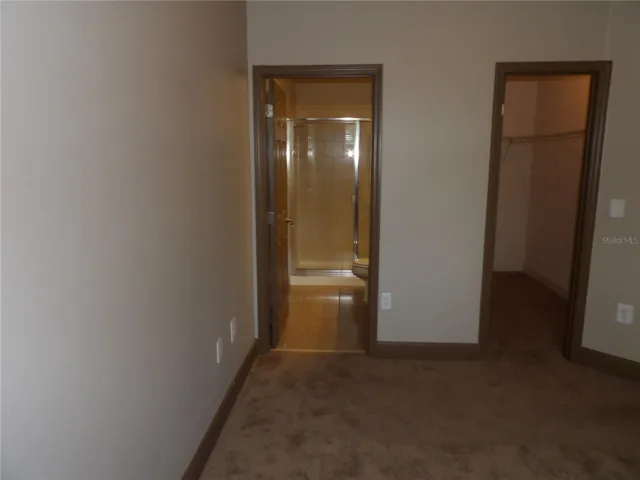primary bedroom with walk in closet and bathroom