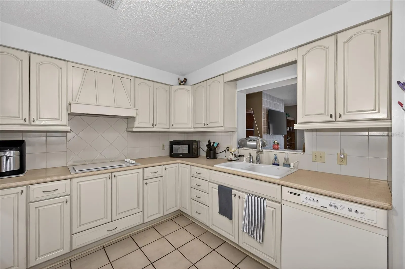 KITCHEN WITH PASS THROUGH WINDOW TO INFORMAL LIVING ROOM