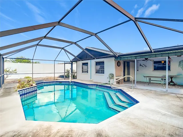 Spacious pool deck with covered outdoor seating area