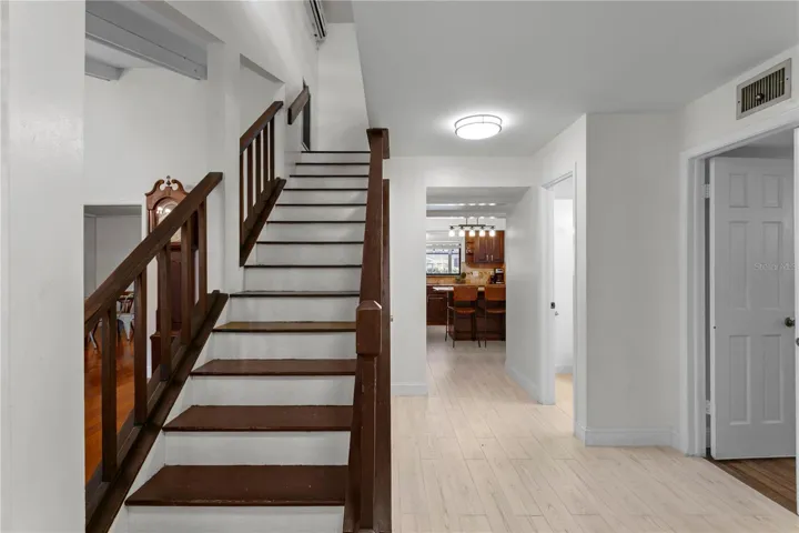 Foyer looking towards the primary suite, hall 1/2 bath and kitchen