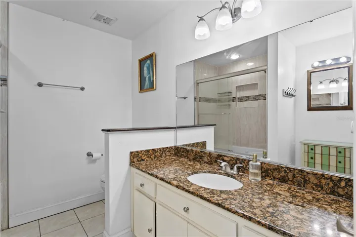 Primary bath with ceramic tile flooring and granite counter top